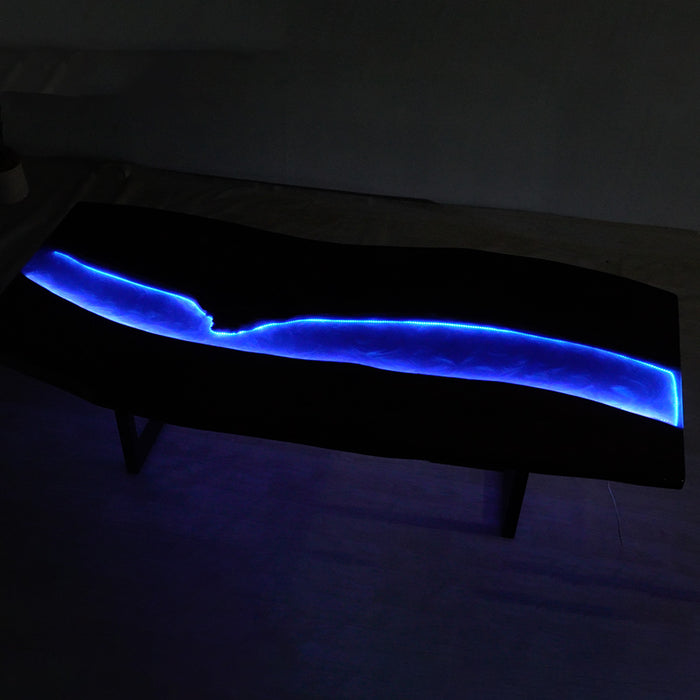 Top view of a walnut LED epoxy table with glowing blue resin river.