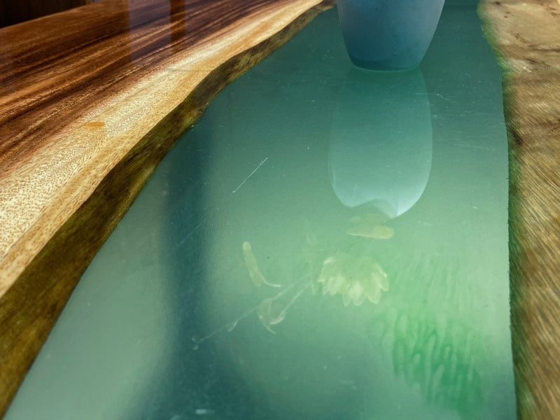 Handmade wood and resin desk with natural edge for workspaces.