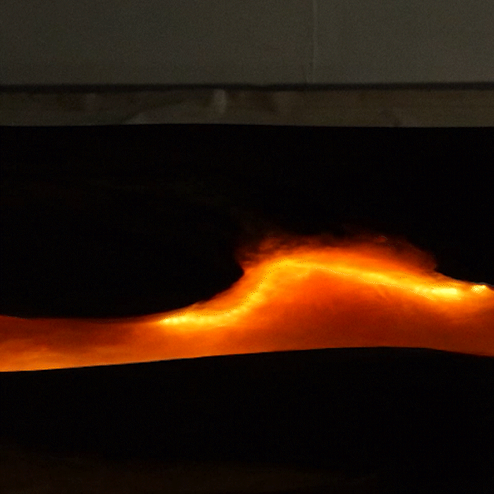 Nighttime view of a glowing fluorescent epoxy resin river table with embedded lighting