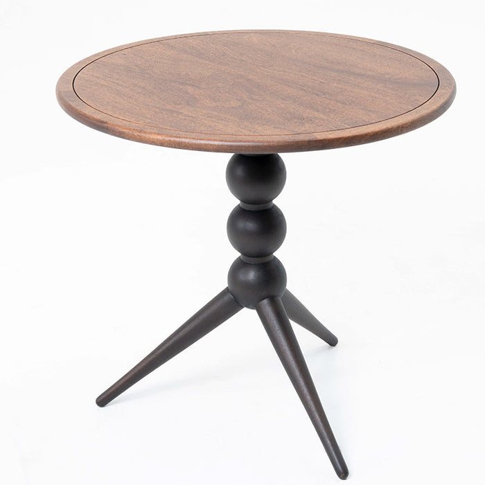 Modern walnut side table with sculptural black tripod legs and round wood top.