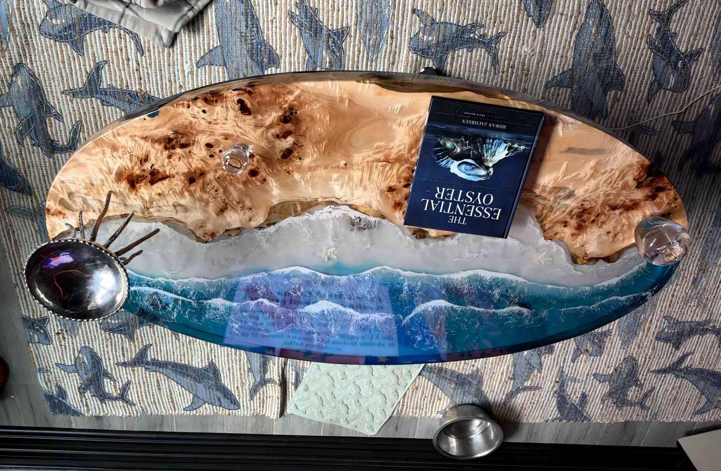 Decorative coffee table with ocean-themed design and a book on top