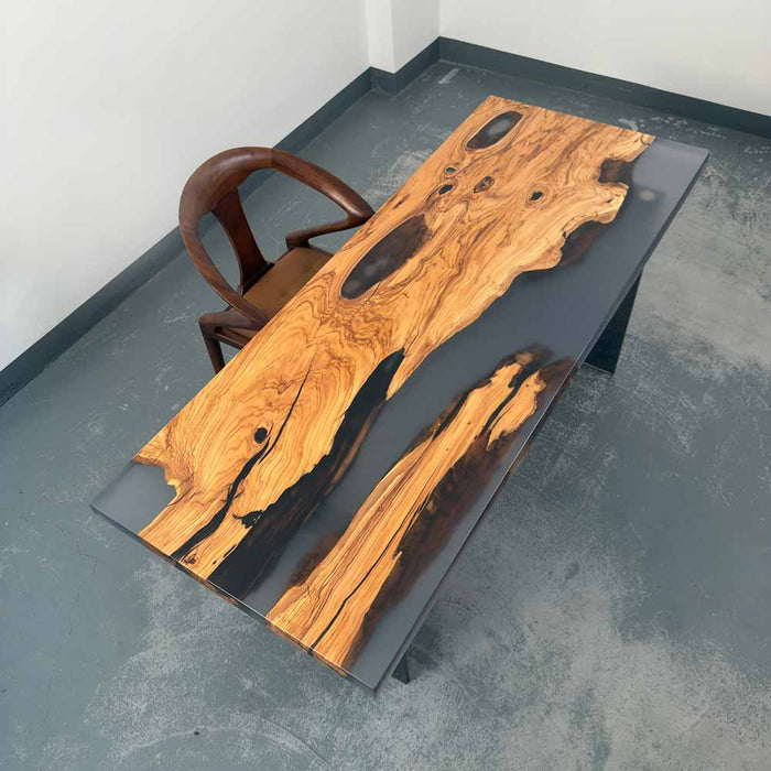 Wooden coffee table with black resin finish on a concrete floor