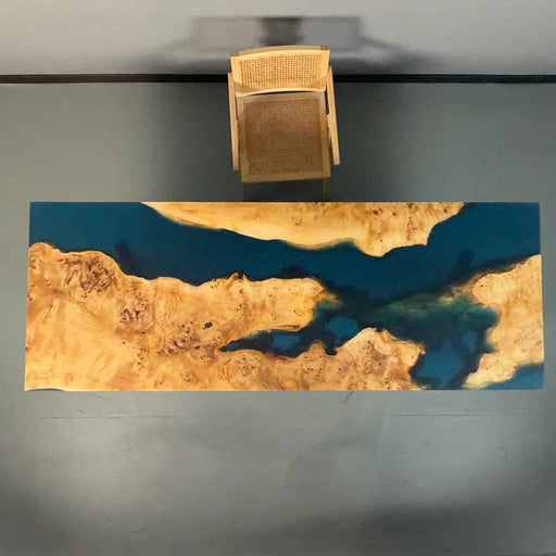 Wooden table with blue resin inlay on a gray surface