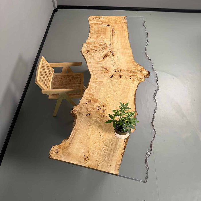 Wooden table with a glass inset and a chair in a minimalistic room.