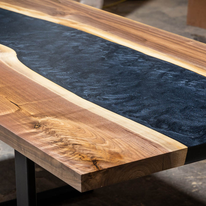 8-seater walnut epoxy table with flowing black resin and solid metal base.