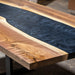 8-seater walnut epoxy table with flowing black resin and solid metal base.