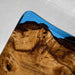 Wooden surface with blue resin finish on a light gray floor