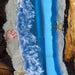 Artistic depiction of a beach scene with blue water, sand, and sea creatures.