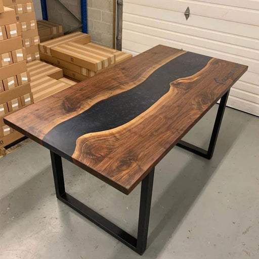 Wooden table with black resin inlay in a warehouse setting