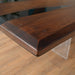 The Custom Black Walnut Epoxy River Table showcases a black walnut live edge slab, seamlessly combined with high-quality epoxy resin to create a stunning contrast. The table top epoxy finish enhances the natural wood grain while providing durability and a glossy shine. Perfect as an epoxy dining table, conference table, or a statement wood and epoxy table for modern interiors. Designed with acrylic legs, this epoxy resin wood table exudes elegance and sophistication. 