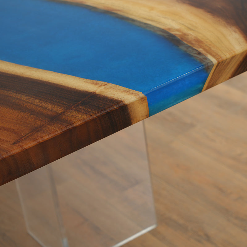 Blue epoxy resin river table featuring a high-gloss finish and natural wood slab, perfect for dining or conference rooms