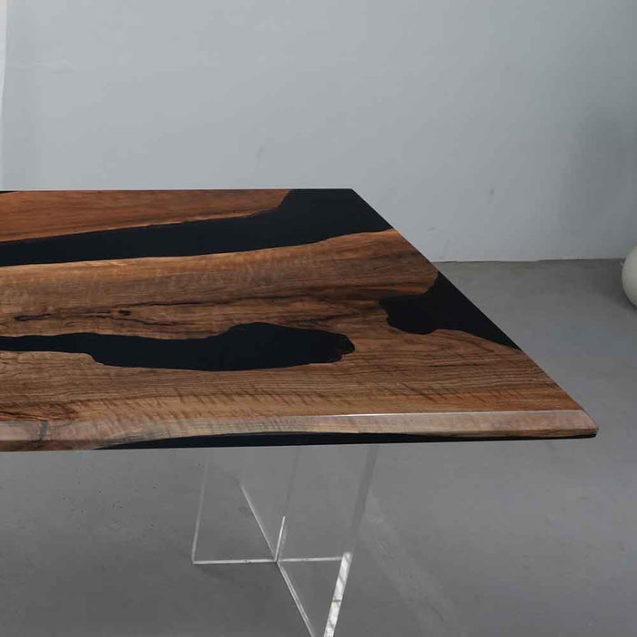 Wooden table with black resin inlay on a gray floor.
