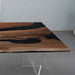 Wooden table with black resin inlay on a gray floor.