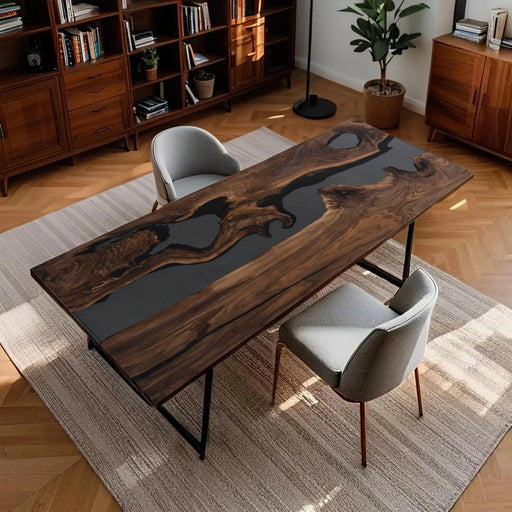 Wooden desk with black glass top in a room with bookshelves and chairs.