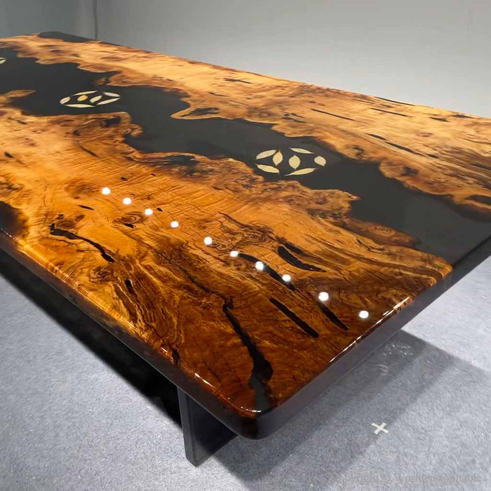 Modern black epoxy river design contrasted with the warm tones of a premium golden camphor slab.