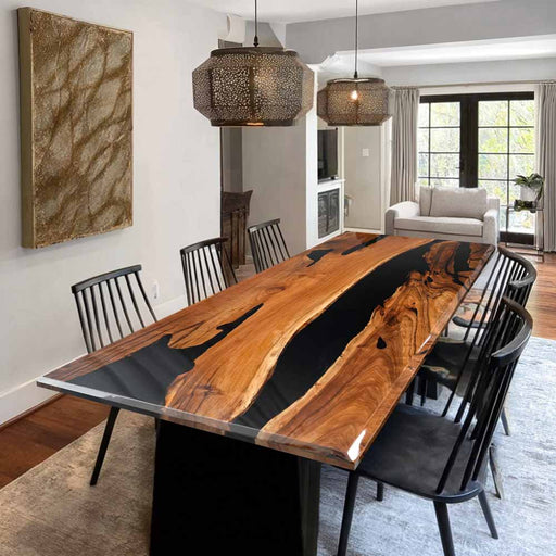 Dining room with a wooden table and black chairs in a modern home setting.