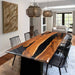 Dining room with a wooden table and black chairs in a modern home setting.