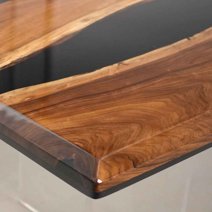 Wooden table with a black glass top on a white background