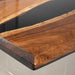 Wooden table with a black glass top on a white background