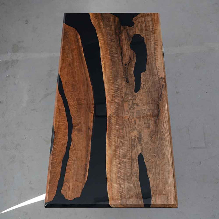 Wooden slab with black resin inlay on a gray surface