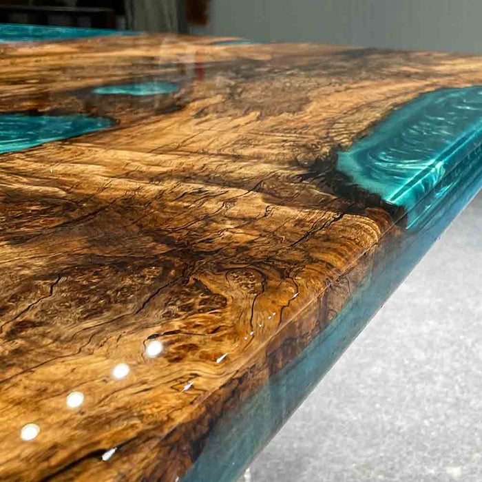Wooden table with blue resin inclusions on a light background