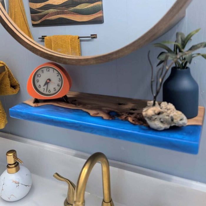 Bathroom with blue shelf, clock, plant, and towel.