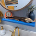Bathroom with blue shelf, clock, plant, and towel.