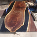 Solid wood black epoxy dining table serving as a statement piece in modern interiors.