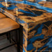 Close-up of blue epoxy river flowing through live edge burl wood