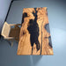 Wooden table with black resin inlay on a blue floor