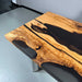 Wooden coffee table with black resin inlay on a gray floor