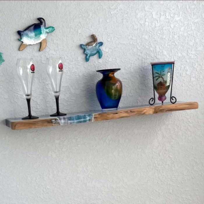 Wooden shelf with decorative items including vases and wall art on a textured white wall.