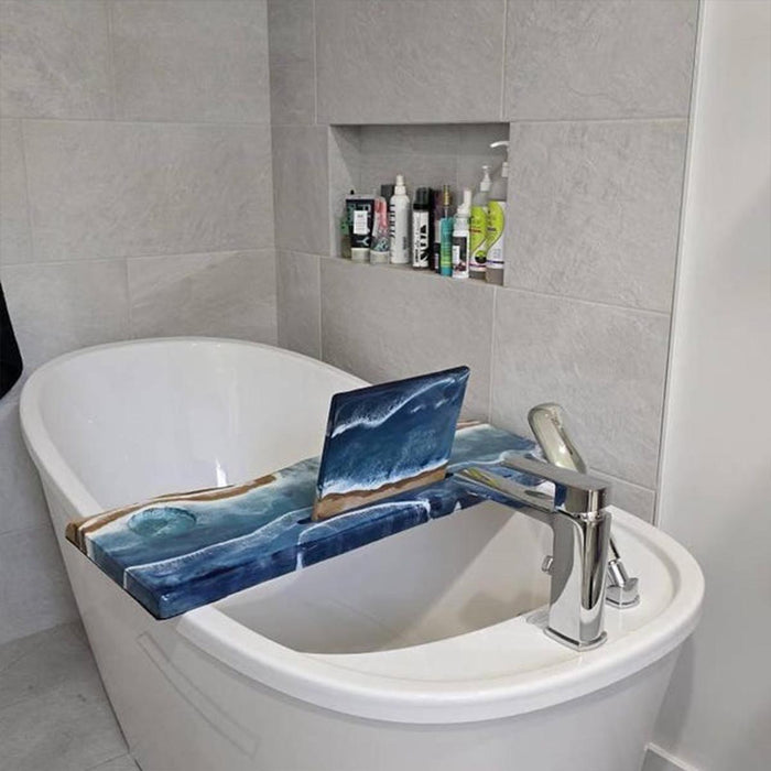 Bathroom setting with a bathtub and laptop on a blue tray