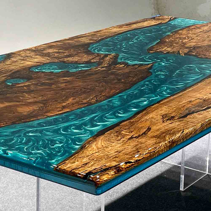 Table with blue resin flowing through wooden planks