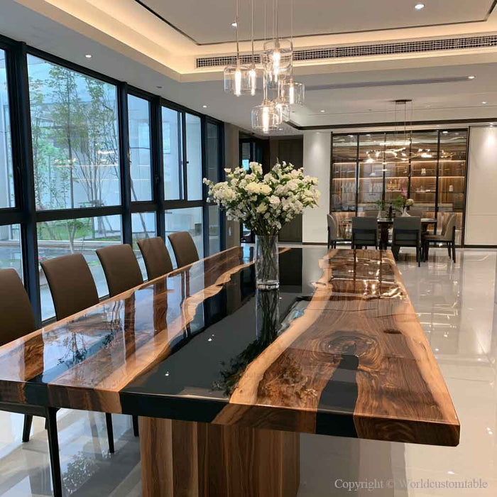 Luxury black walnut dining table featuring a glossy black epoxy river center and natural live edge wood slabs in a modern dining room.