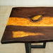 Amber-colored resin glowing through the natural wood grain of a walnut table.