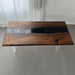 Black epoxy river dining table in a modern kitchen with mountain view.