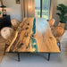 Artisan handcrafted olive wood and blue epoxy river table for modern dining spaces.