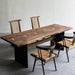 Artisan live edge walnut dining table with black metal base and woven seat chairs.