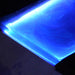 Artisan live-edge walnut epoxy table with embedded glowing blue epoxy.