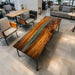Artistic tabletop featuring natural wood grain blended with dark resin, showcasing flowing patterns and a glossy finish that merges nature with contemporary design.