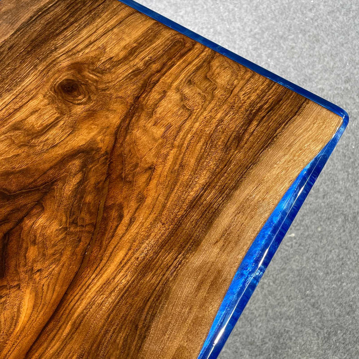 Wooden surface with blue resin border on a gray background