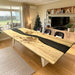 Large poplar wood and black epoxy dining table in a designer meeting space