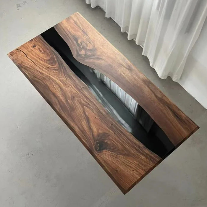 Black epoxy river dining table in a modern kitchen with mountain view.