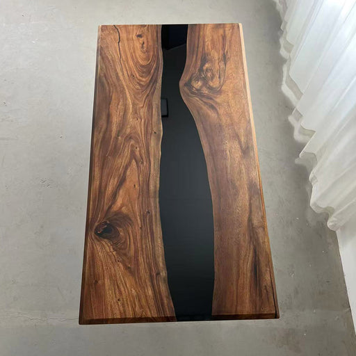 Black epoxy river dining table in a modern kitchen with mountain view.