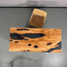 Wooden coffee table with natural grain and black resin inclusions on a gray background
