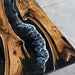 Wooden table with blue resin inlay on a concrete floor