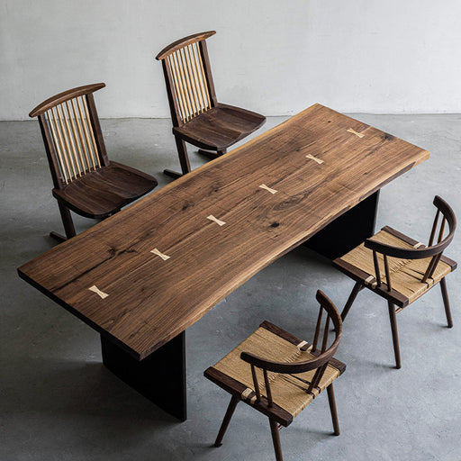 Solid black walnut dining table with butterfly joints and minimalist wood chairs.