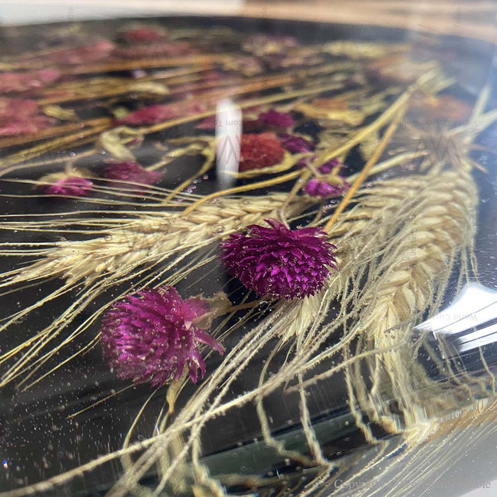 Black walnut epoxy dining table featuring an elegant botanical design sealed in resin.