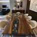 Black walnut epoxy dining table with floral resin flowing through the center in a luxury dining room setting
